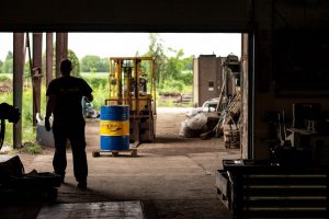 Forklift transports a barrel of flammable liquid.