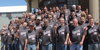 Group photo of Warehouse1 employee owners in front of the office building.