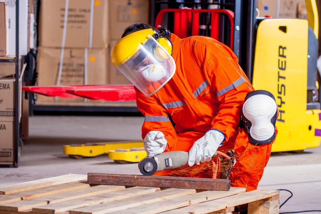 Employee operates a grinder while wearing PPE equipment.
