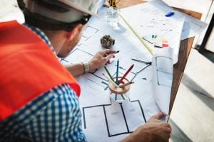 Warehouse employee looks at layout design drawing.