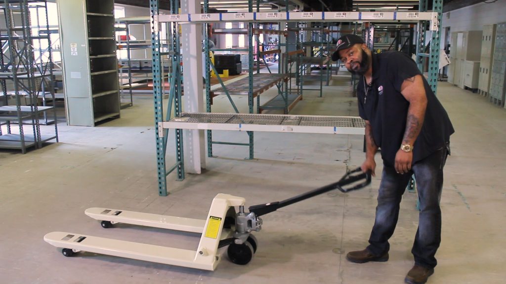 Employee shows how to use a newly assembled pallet jack.