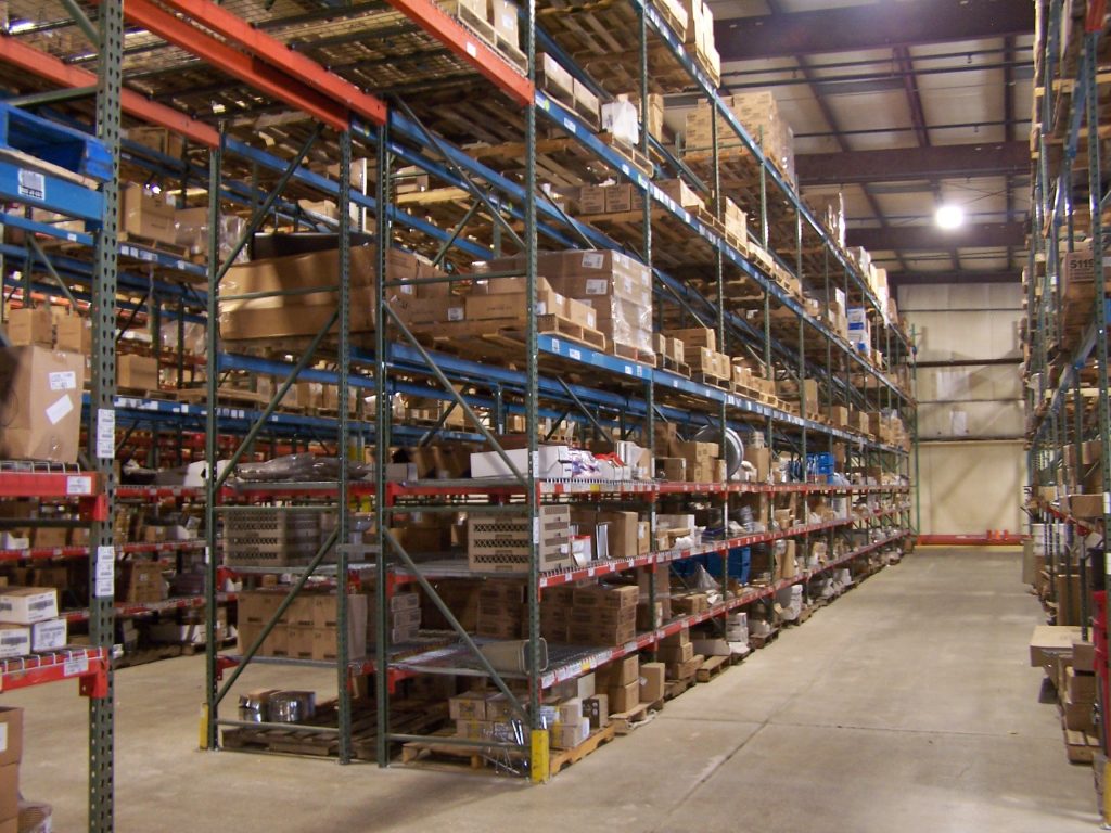 Interior warehouse with rows of used pallet racking.