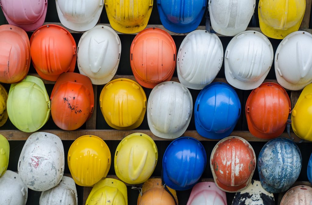 Multi-color hard hats attached to a wall.