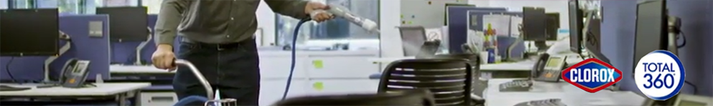 Employee sanitizing workspaces