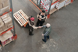 3 warehouse workers having a friendly discussion.
