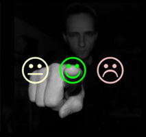 Man pointing at a green smiley face; two other faces include a frown face and a neutral face