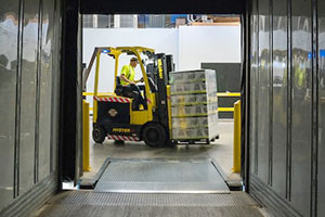 Employee backing a forklift up and checking behind them.