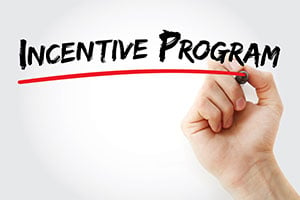 Hand underlining the words “incentive program”.