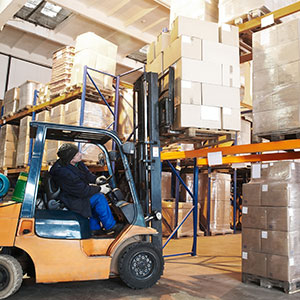 Forklift loads pallets onto pallet rack.