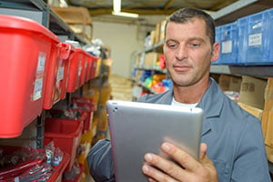 Warehouse worker uses a tablet to track inventory.