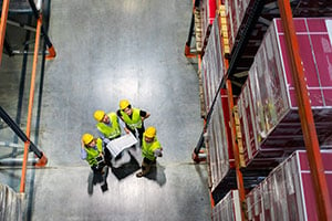 A group of warehouse employees reviews unused vertical space.