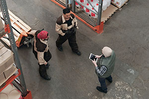 Experienced warehouse worker meets with newer employees.