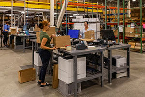 Two workers at shipping stations.