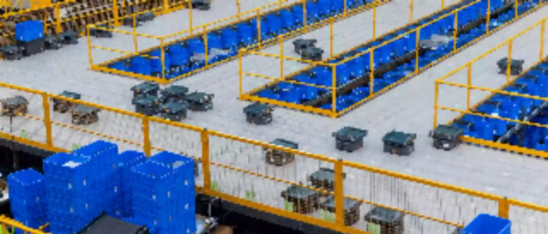 Multiple sorting robots work in a warehouse full of bins