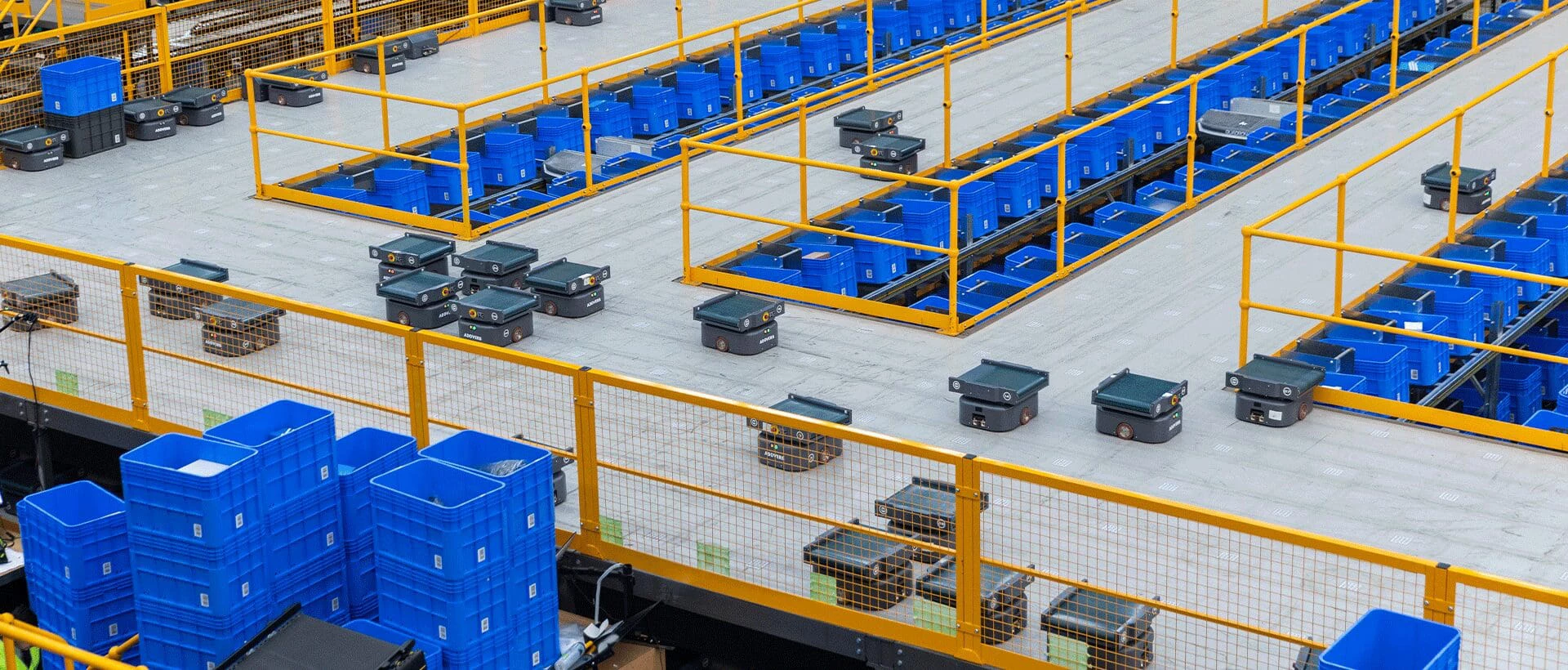 multiple sorting robots work in a warehouse full of bins