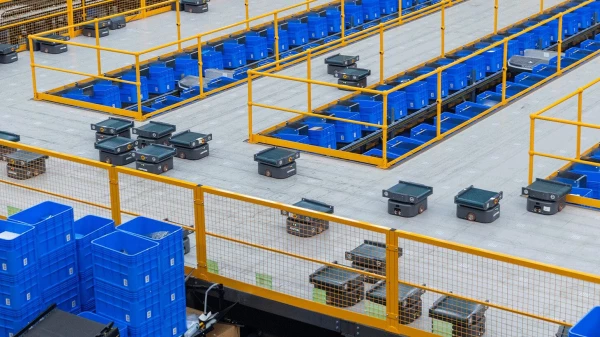 multiple sorting robots work in a warehouse full of bins