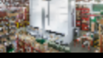 Smart warehouse with two vertical lift modules among shelving and pallet rack