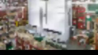 Smart warehouse with two vertical lift modules among shelving and pallet rack