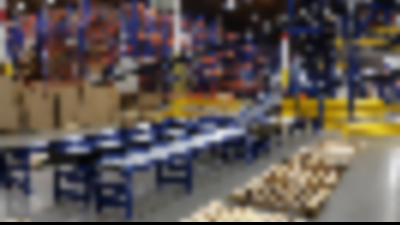 Automated conveyor in a warehouse with pallet rack system in the background