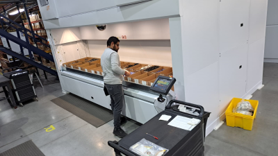 Warehouse employee uses automated storage solution called a vertical lift module