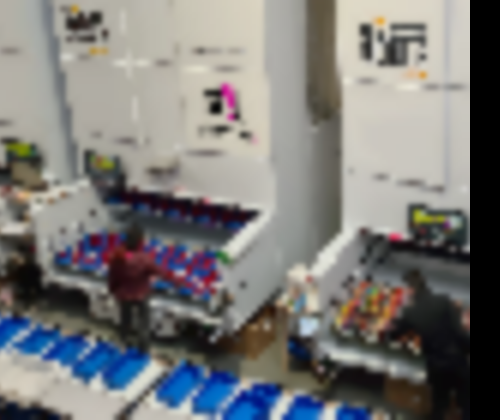 Two employees pick parts from vertical lift module trays