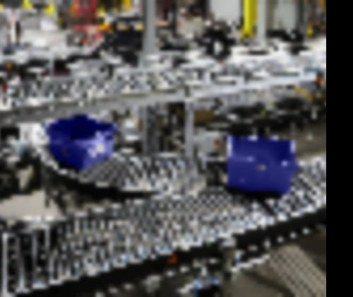 Blue bins divert on rollers of a conveyor system