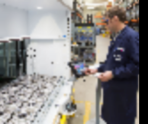 An employee picks parts from vertical lift module tray