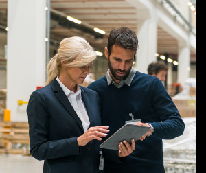 Employees check over a warehouse equipment list on a tablet